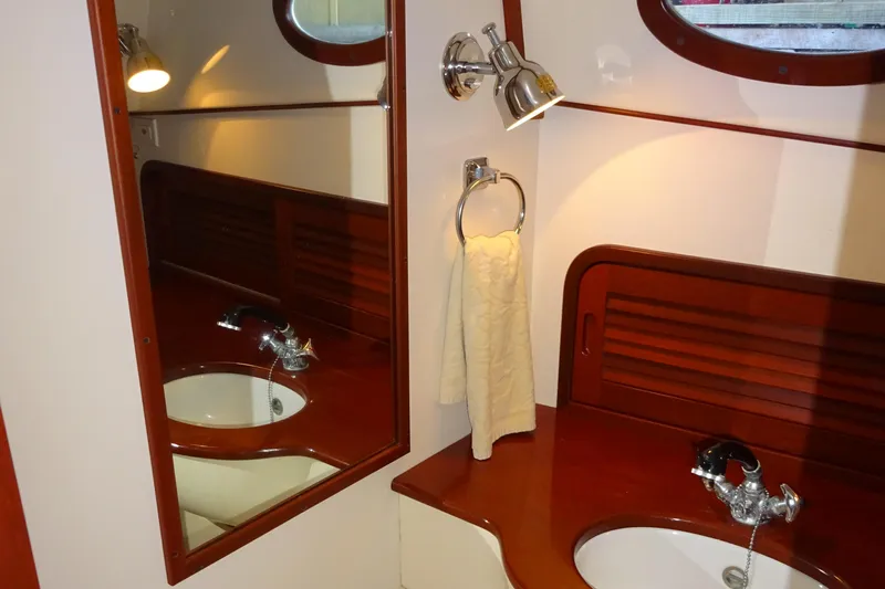 Blue Moon Yacht Photos Pics Elegant bathroom interior of 1995 Hinckley Picnic Boat Classic with wooden accents and mirror.
