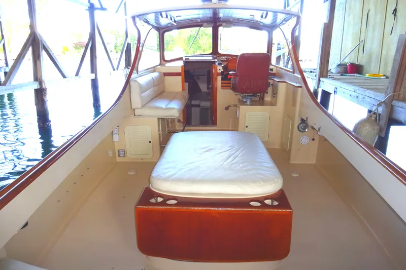 Blue Moon Yacht Photos Pics 1995 Hinckley Picnic Boat Classic interior with seating and helm, docked in a boathouse.