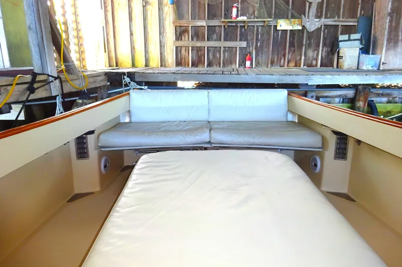 Blue Moon Yacht Photos Pics 1995 Hinckley Picnic Boat Classic interior with cushioned seating in a wooden boathouse.