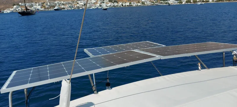  Yacht Photos Pics Solar panels on a 2006 Hanse 461 yacht, with a scenic coastal backdrop.