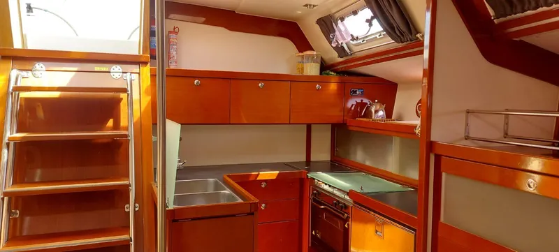  Yacht Photos Pics Interior of 2006 Hanse 461 yacht kitchen with wooden cabinetry and modern appliances.