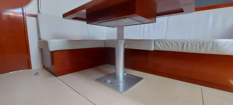  Yacht Photos Pics Interior of 2006 Hanse 461 yacht with wooden table and white cushioned seating.