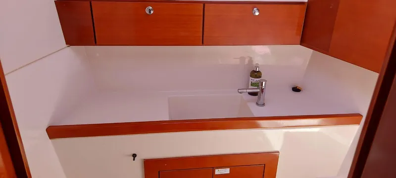  Yacht Photos Pics Wooden yacht kitchen with sink, faucet, and storage cabinets on a 2006 Hanse 461.