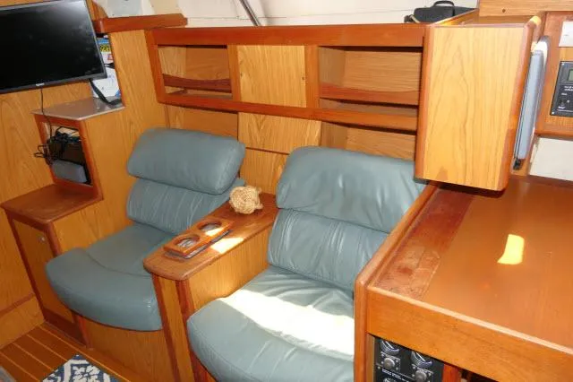 Ale Er Ron Yacht Photos Pics Interior of 2000 Hunter 460 yacht with blue leather seating and wooden cabinetry.