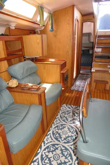 Ale Er Ron Yacht Photos Pics Interior of 2000 Hunter 460 sailboat with wood finish and blue seating.