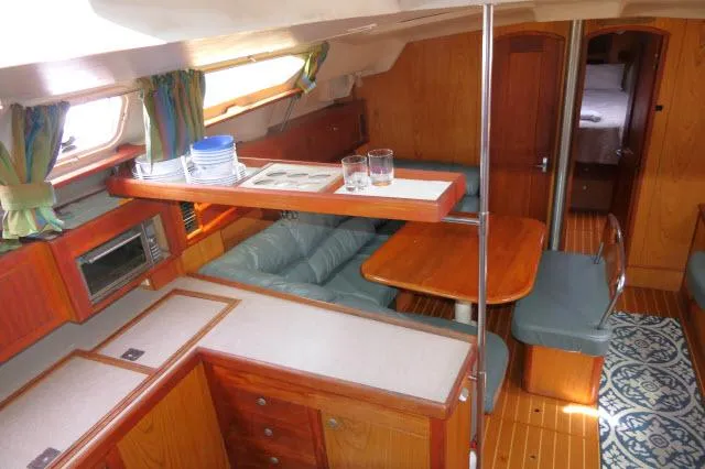 Ale Er Ron Yacht Photos Pics Interior of 2000 Hunter 460 sailboat with cozy seating and wooden cabinetry.