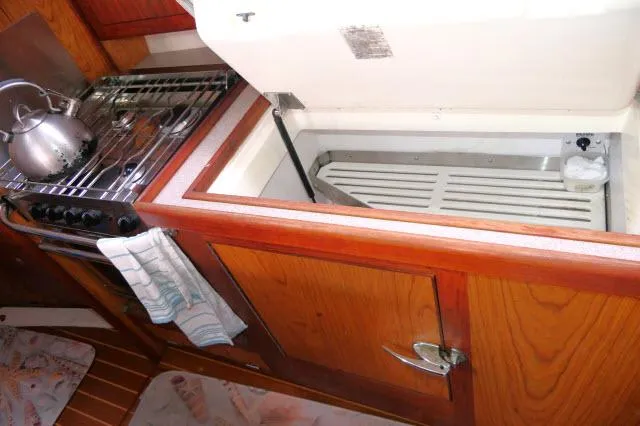 Ale Er Ron Yacht Photos Pics Wooden yacht kitchen with stove, kettle, and open storage compartment. Hunter 460, 2000 model.