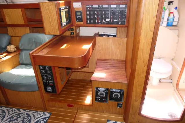 Ale Er Ron Yacht Photos Pics Interior of 2000 Hunter 460 sailboat with navigation station and wooden cabinetry.