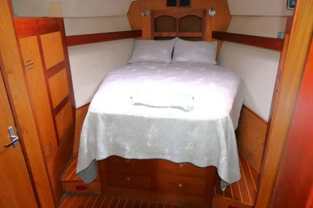 Ale Er Ron Yacht Photos Pics Cozy cabin interior of 2000 Hunter 460 yacht with wooden furnishings and a double bed.