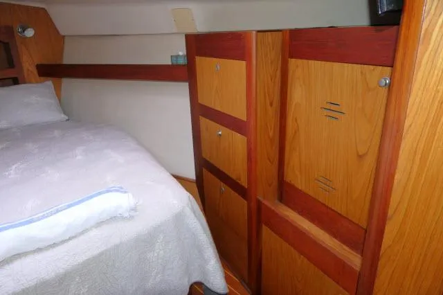 Ale Er Ron Yacht Photos Pics Cozy cabin interior of 2000 Hunter 460 sailboat with wooden storage and bed.