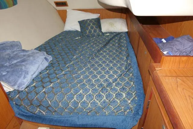 Ale Er Ron Yacht Photos Pics Cozy cabin bed in 2000 Hunter 460 sailboat with blue patterned bedding.