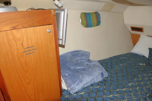 Ale Er Ron Yacht Photos Pics Cozy cabin interior of 2000 Hunter 460 sailboat with wooden cabinet and blue bedding.