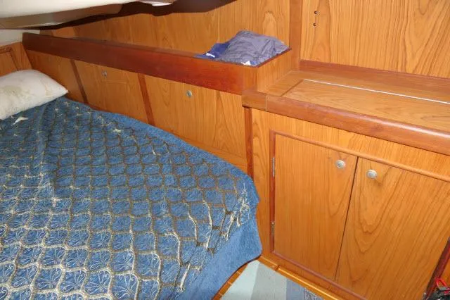 Ale Er Ron Yacht Photos Pics Cozy cabin interior of 2000 Hunter 460 sailboat with wooden cabinetry and blue bedding.