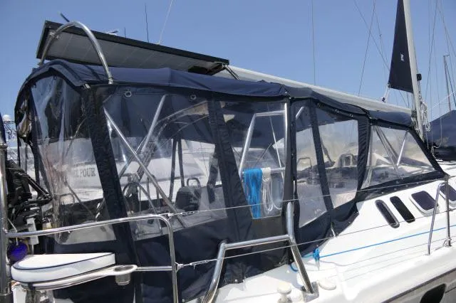 Ale Er Ron Yacht Photos Pics 2000 Hunter 460 sailboat with blue canvas enclosure in marina.