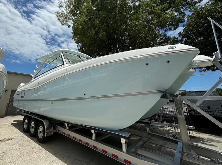 Wcn 51988 325dc Wht Mer350 Yacht Photos Pics 2024 World Cat 325 DC boat on a trailer, side view under a partly cloudy sky.