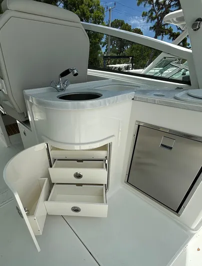 Wcn 51988 325dc Wht Mer350 Yacht Photos Pics 2024 World Cat 325 DC boat interior with sink, storage drawers, and mini fridge.