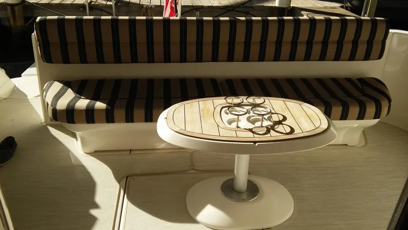 First Light Yacht Photos Pics 2005 Sea Ray 550 Sedan Bridge boat interior with striped seating and wooden table.