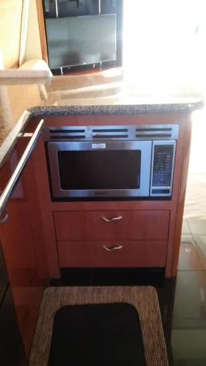 First Light Yacht Photos Pics 2005 Sea Ray 550 Sedan Bridge kitchen with built-in microwave and granite countertop.