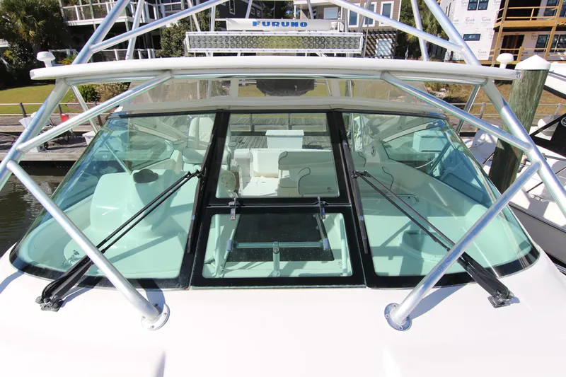 Bloody Knuckles Yacht Photos Pics 2008 Bertram 360 boat cockpit with windshield and metal frame, docked at marina.