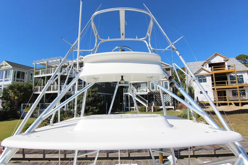 Bloody Knuckles Yacht Photos Pics 2008 Bertram 360 yacht with tower against a clear blue sky and waterfront homes.