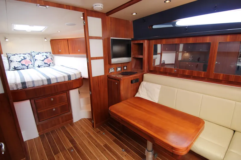 Bloody Knuckles Yacht Photos Pics Interior of 2008 Bertram 360 yacht with wood finish, bed, and seating area.