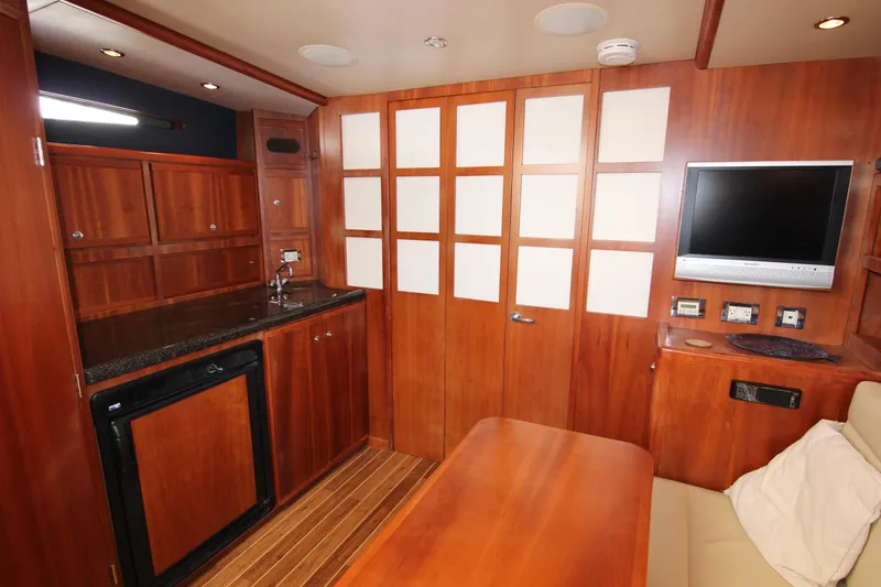 Bloody Knuckles Yacht Photos Pics Luxurious 2008 Bertram 360 yacht interior with wood cabinetry, kitchenette, and TV.