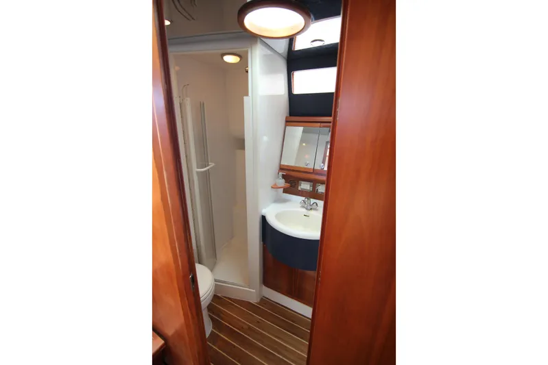 Bloody Knuckles Yacht Photos Pics 2008 Bertram 360 yacht bathroom with wooden accents and modern fixtures.