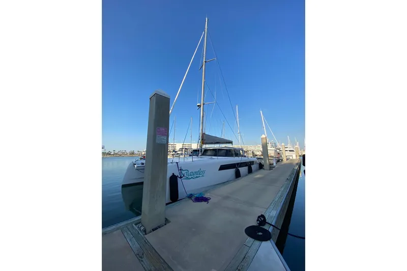 Dauntless Yacht Photos Pics 2024 Seawind 1370 catamaran docked at marina under clear blue sky.