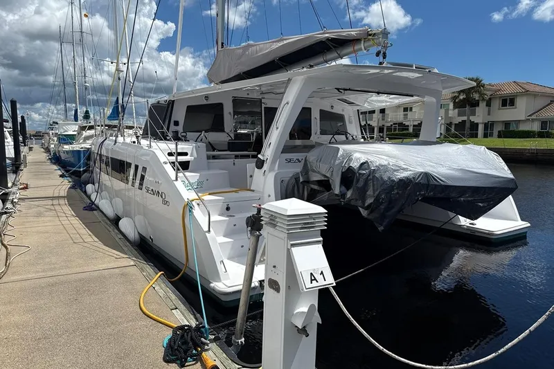 Dauntless Yacht Photos Pics 2024 Seawind 1370 catamaran docked at marina under a partly cloudy sky.
