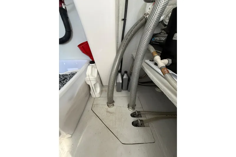 Dauntless Yacht Photos Pics Engine compartment of 2024 Seawind 1370 with hoses and maintenance supplies.