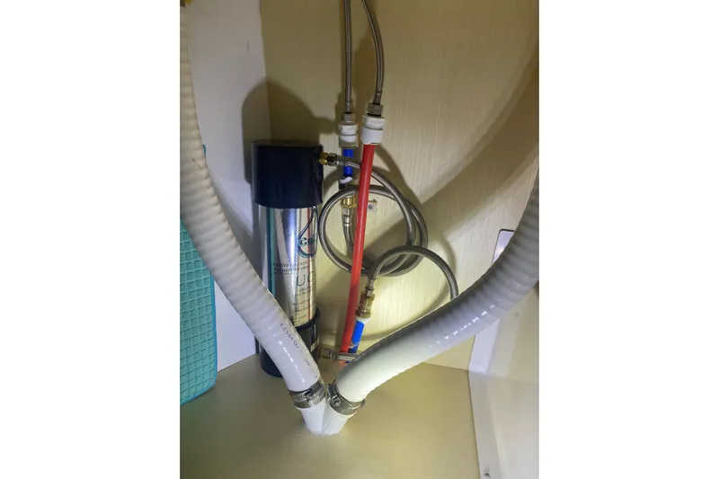 Dauntless Yacht Photos Pics Plumbing system inside 2024 Seawind 1370 yacht, featuring hoses and filtration unit.