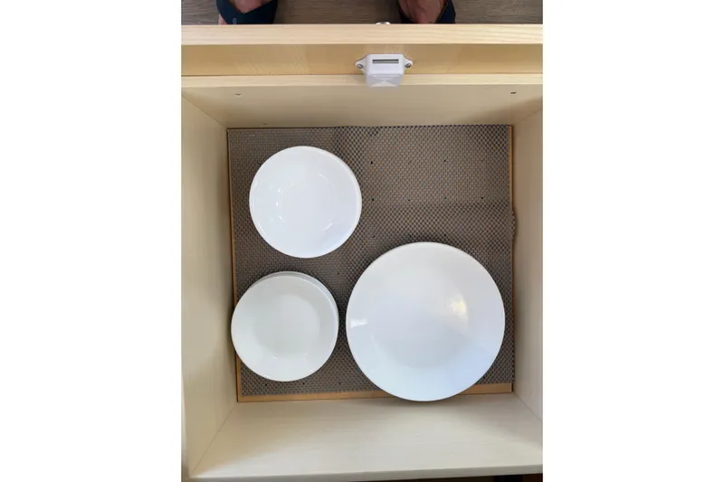 Dauntless Yacht Photos Pics White dishes neatly arranged in a drawer on a Seawind 1370, 2024 model.