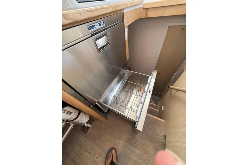 Dauntless Yacht Photos Pics 2024 Seawind 1370 yacht interior with open stainless steel dishwasher drawer.