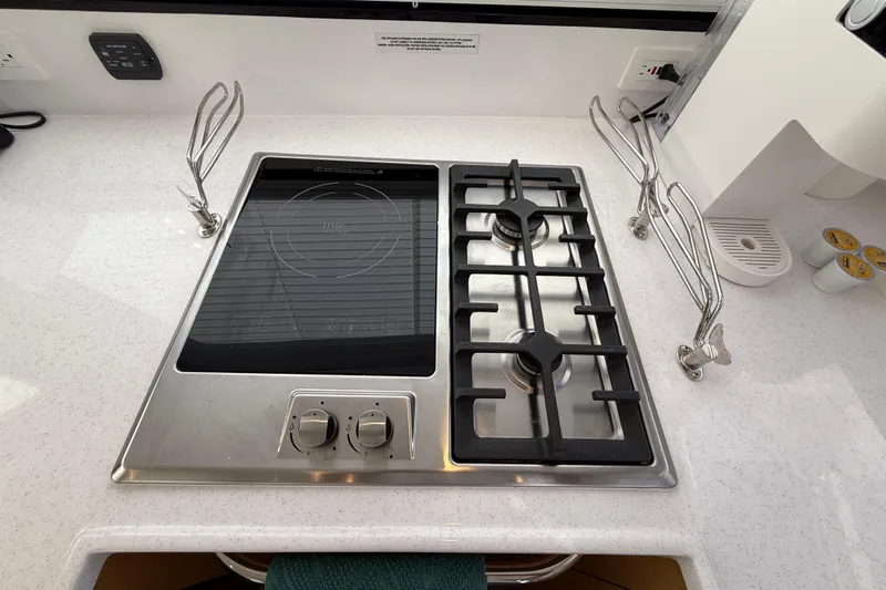 Dauntless Yacht Photos Pics Modern kitchen stove on 2024 Seawind 1370 yacht, featuring gas burners and induction cooktop.