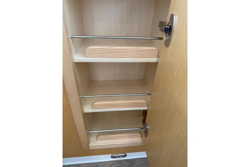 Dauntless Yacht Photos Pics Wooden cabinet shelves inside 2024 Seawind 1370 model, featuring metal railings.