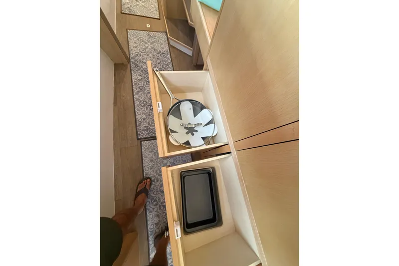 Dauntless Yacht Photos Pics Interior storage of 2024 Seawind 1370 yacht with open cabinets and cookware.