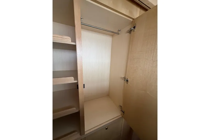 Dauntless Yacht Photos Pics 2024 Seawind 1370 interior closet with wooden shelves and hanging rod.