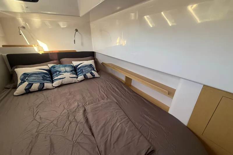 Dauntless Yacht Photos Pics 2024 Seawind 1370 cabin interior with cozy bed and decorative pillows.