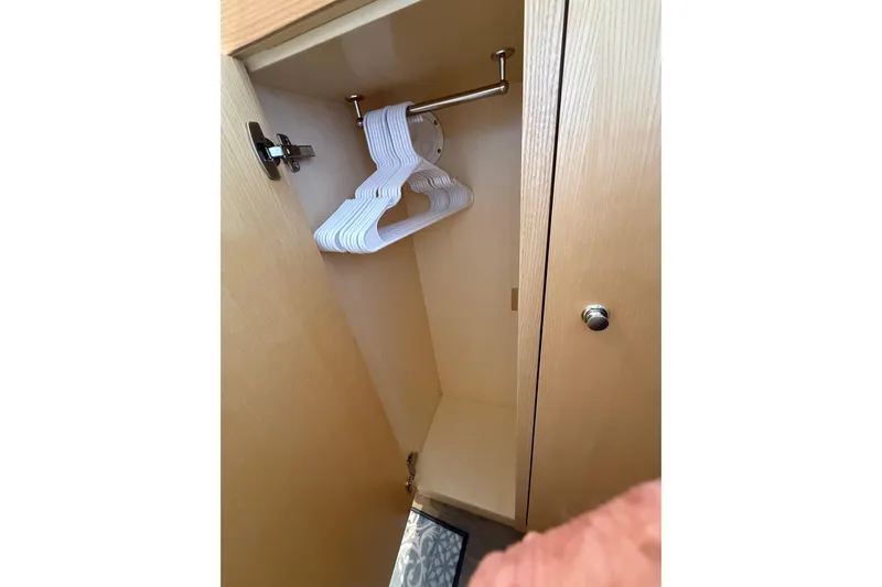 Dauntless Yacht Photos Pics 2024 Seawind 1370 yacht closet with hangers, wooden interior.