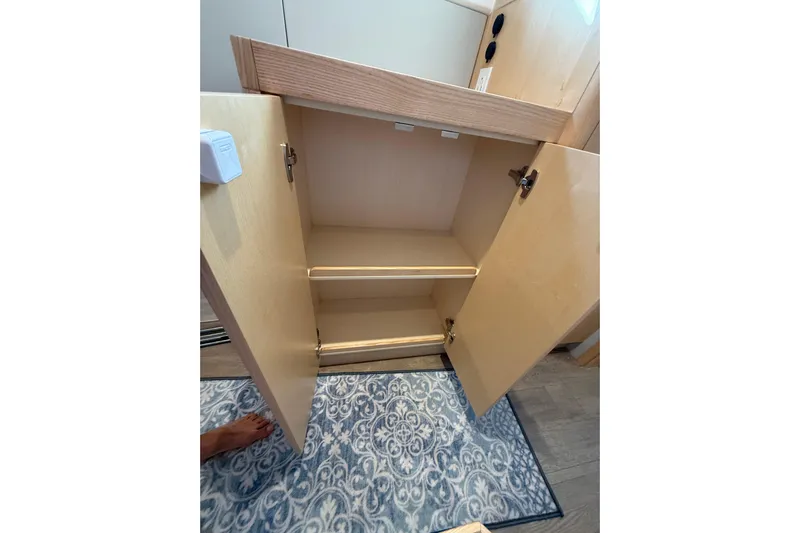 Dauntless Yacht Photos Pics Open cabinet with shelves inside a 2024 Seawind 1370 boat interior.