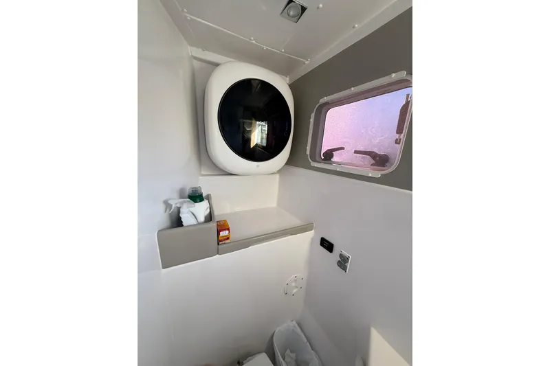 Dauntless Yacht Photos Pics 2024 Seawind 1370 interior with compact washing machine and window view.