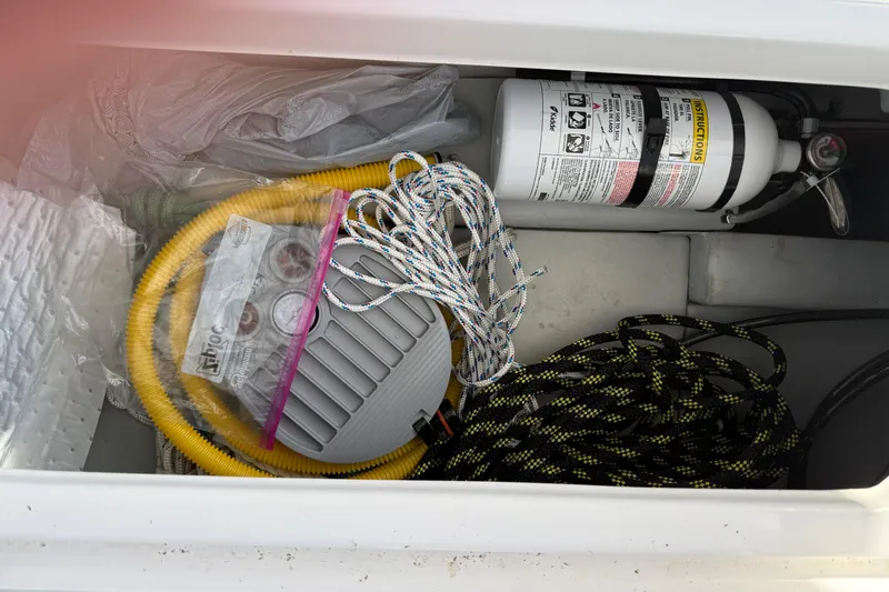 Dauntless Yacht Photos Pics Storage compartment of 2024 Seawind 1370 with ropes, hose, and fire extinguisher.