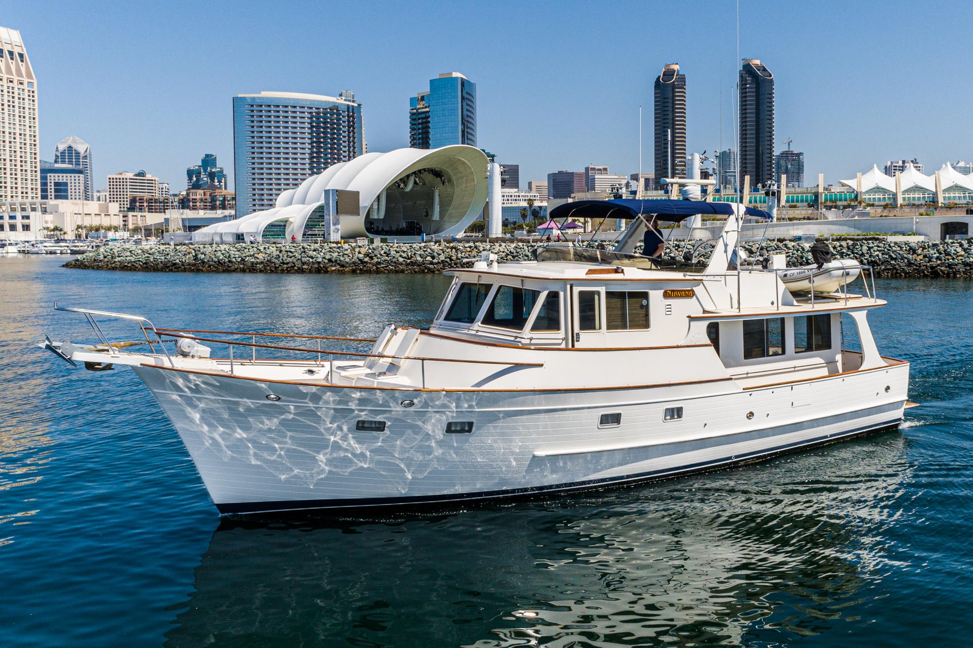 1987 Fleming 50 Raised Pilothouse yacht cruising in urban waterfront setting.