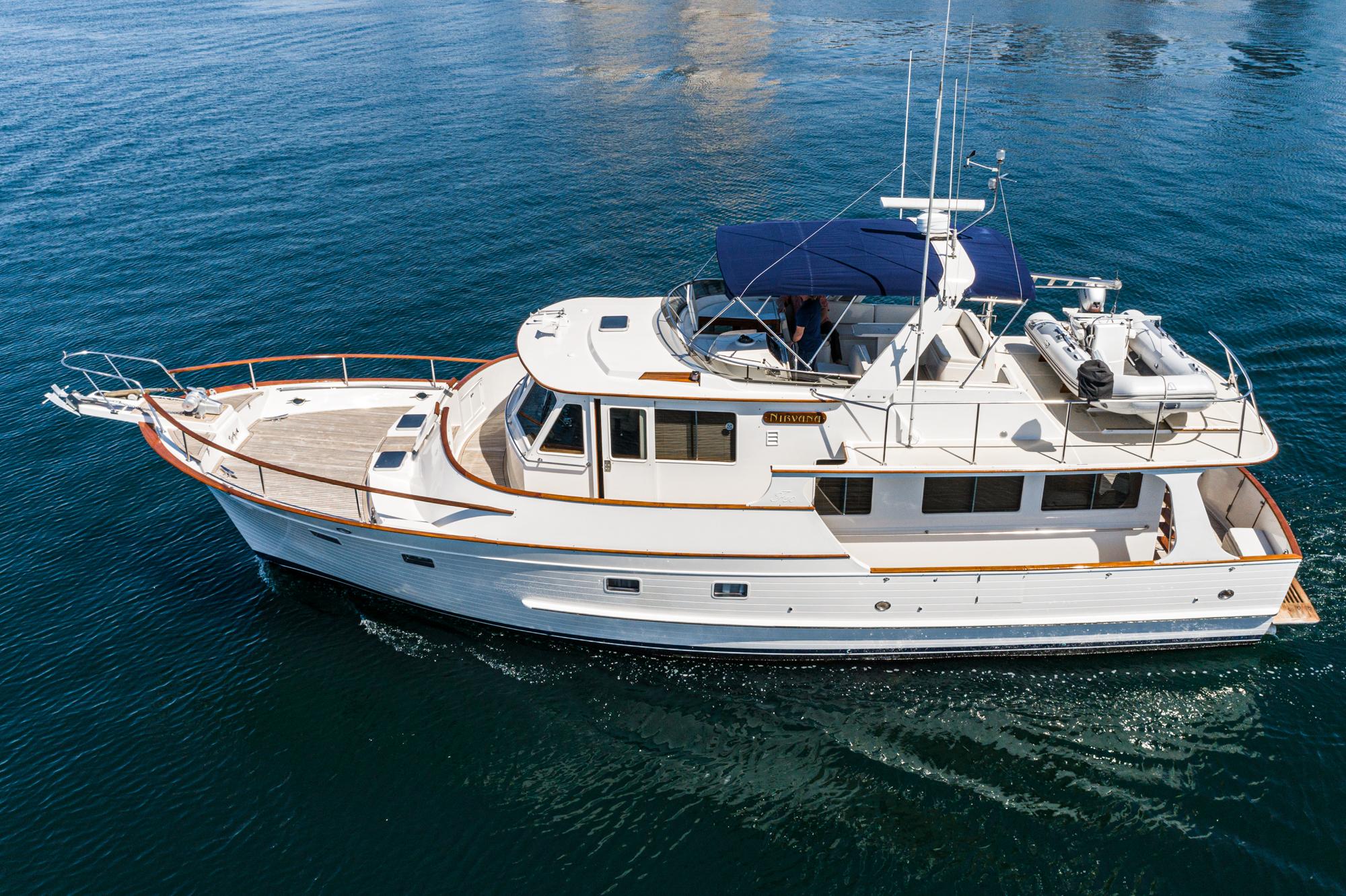 1987 Fleming 50 Raised Pilothouse yacht cruising on calm blue waters.