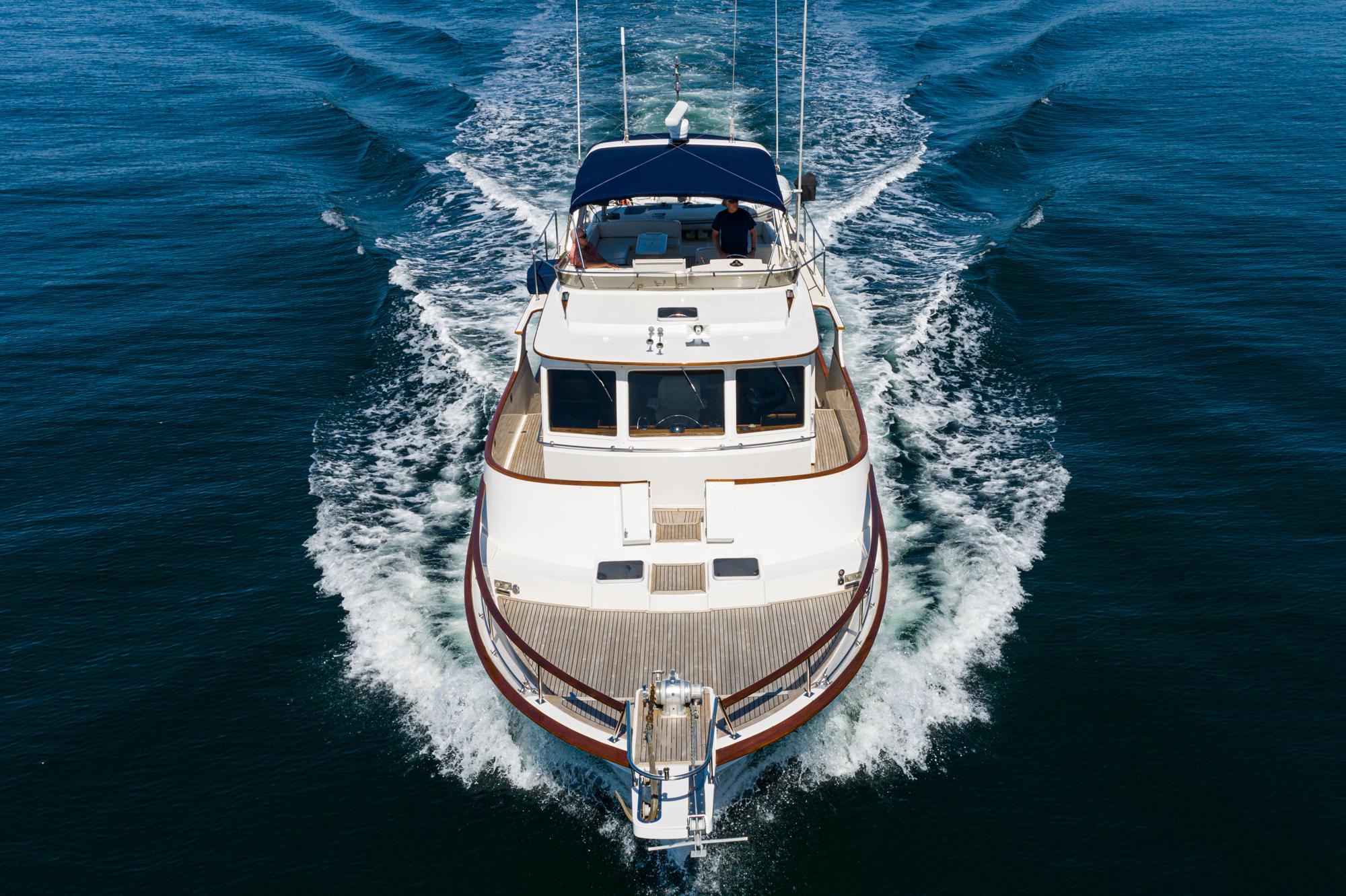 1987 Fleming 50 Raised Pilothouse yacht cruising on open water, aerial view.