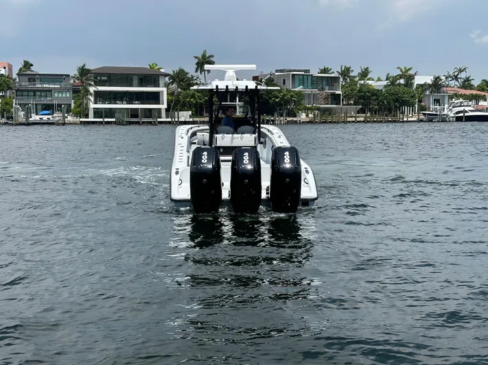  Yacht Photos Pics 2024 Yellowfin 34 Offshore boat with four engines on a calm waterfront.