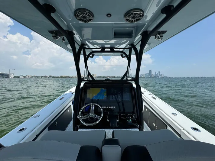  Yacht Photos Pics 2024 Yellowfin 34 Offshore boat interior with navigation system, steering wheel, and ocean view.