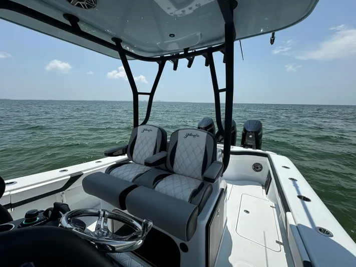  Yacht Photos Pics 2024 Yellowfin 34 Offshore boat interior with dual seats, steering wheel, and ocean view.