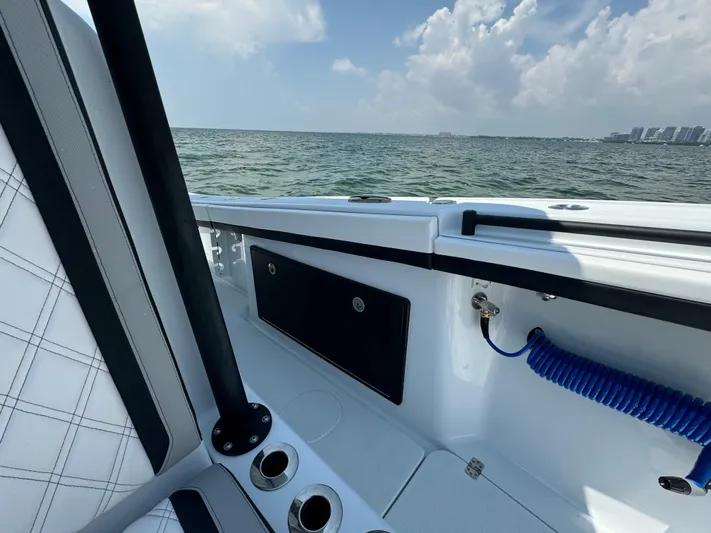  Yacht Photos Pics 2024 Yellowfin 34 Offshore boat interior with ocean view, featuring seating and cup holders.