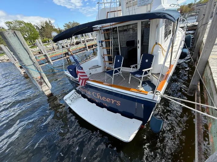  Yacht Photos Pics Sabreline 34 Flybridge 1999 docked, featuring a spacious deck with chairs and an American flag.